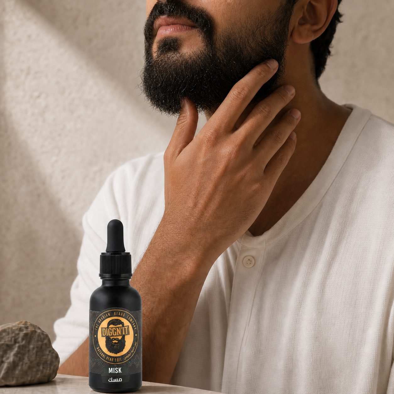 Man touching his beard beside Diggn'It Misk Arabian Beard Oil