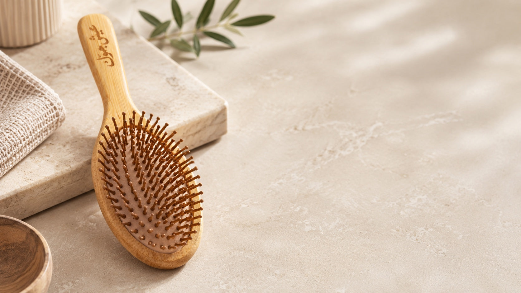 DiggnIt bamboo hair brush on a warm bathroom stone surface