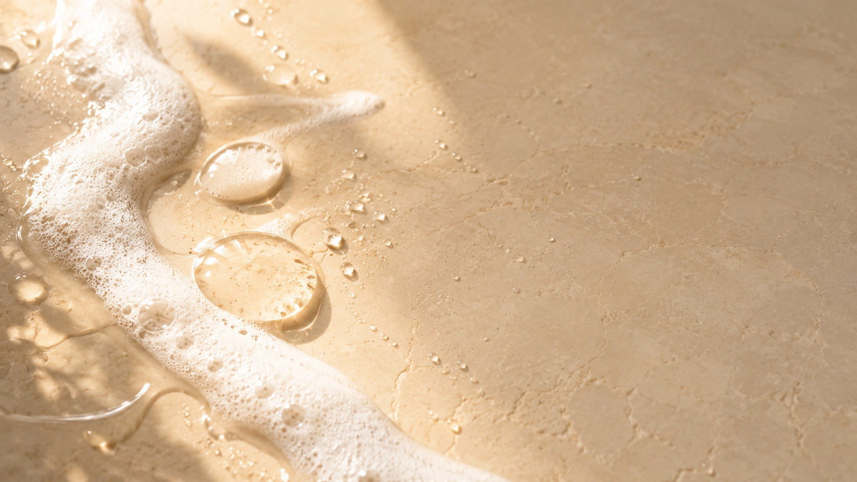 Clear droplets and soft lather ribbon on wet stone