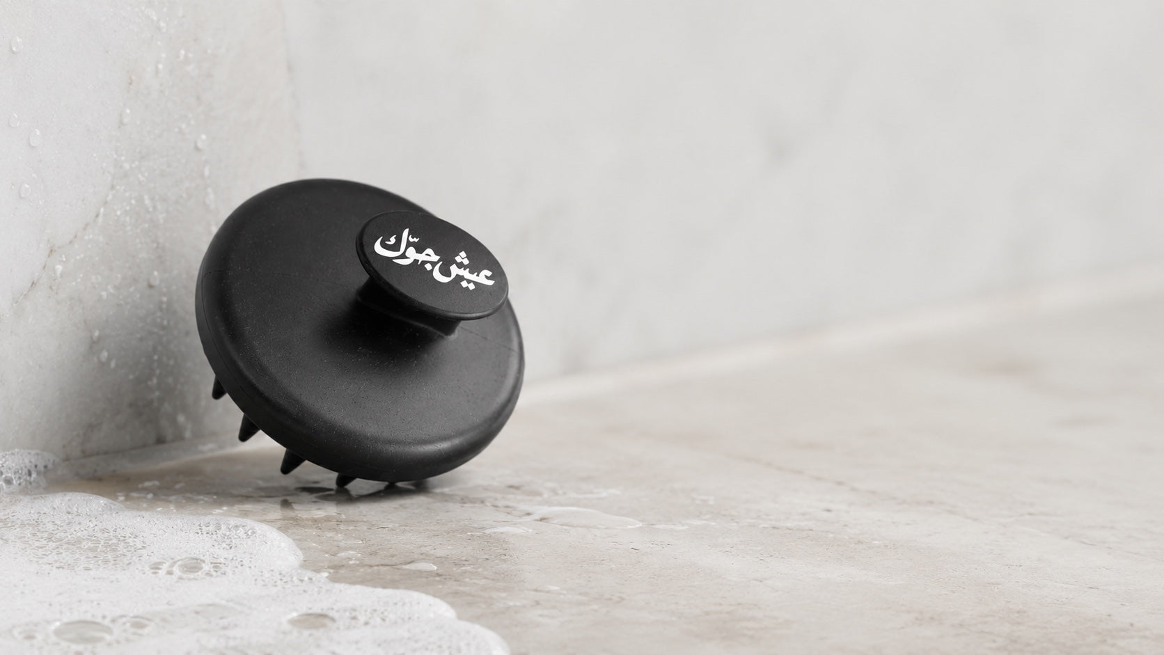DiggnIt beard and hair scrubber in a stone shower setting with light foam